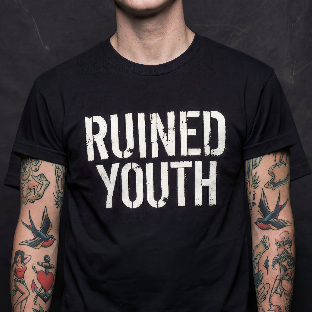 Person wearing a black t-shirt with 'RUINED YOUTH' text, tattoos visible on arms.